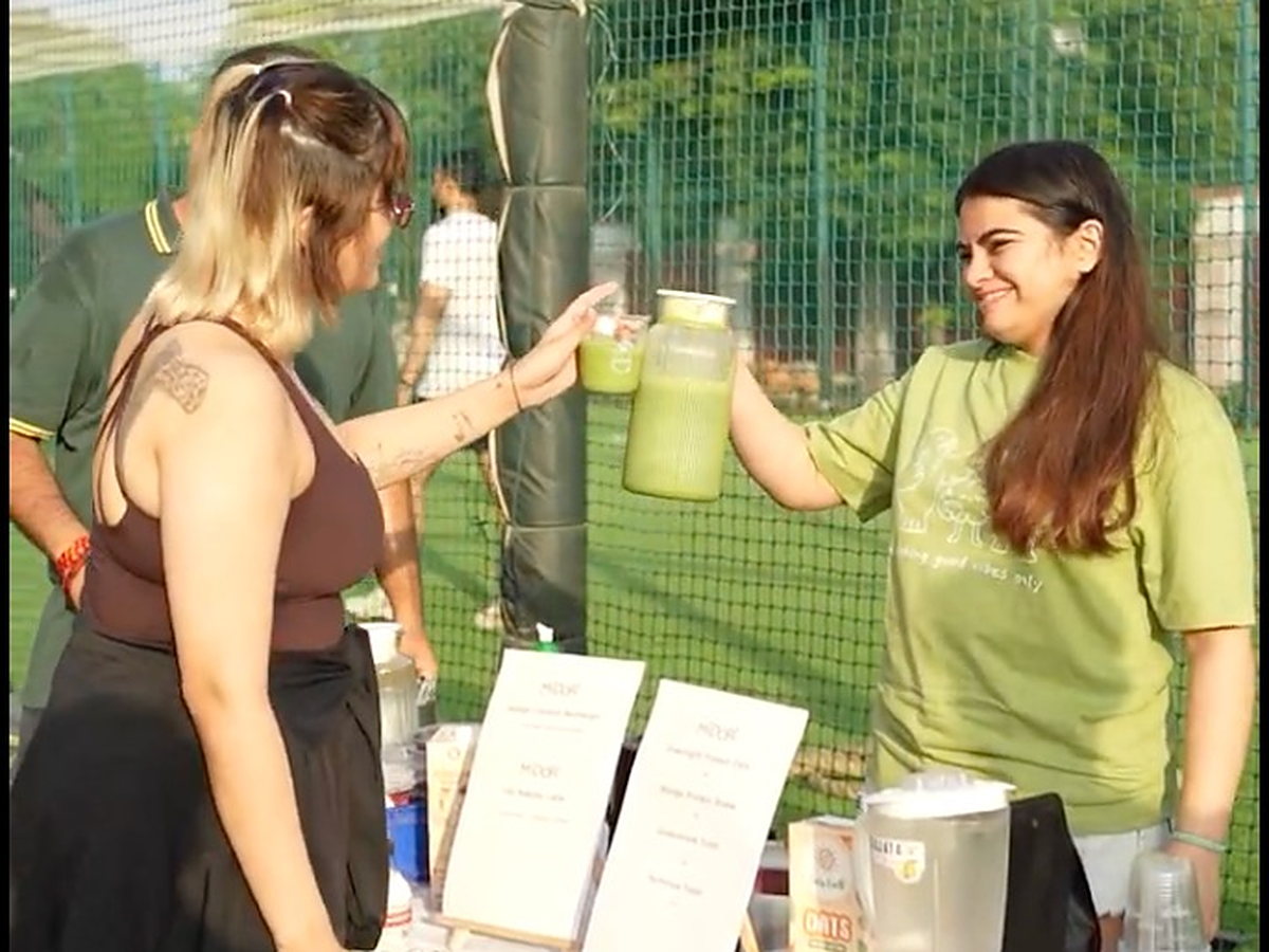 A Midori team member hands a fresh drink across their stall to a participant at the Jaipur pilot.